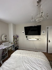 a bedroom with a tv mounted on the wall
